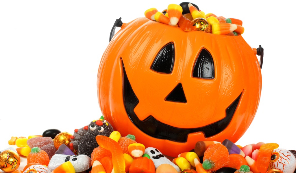 Тыква со сладостями на белом фоне