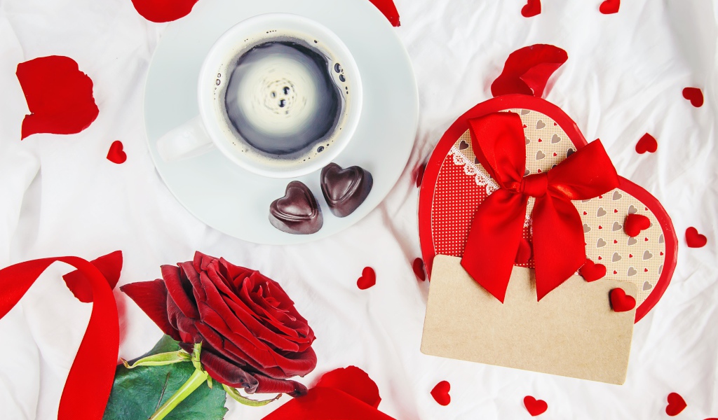 Чашка кофе на столе с коробкой в форме сердца и красной розой для любимой