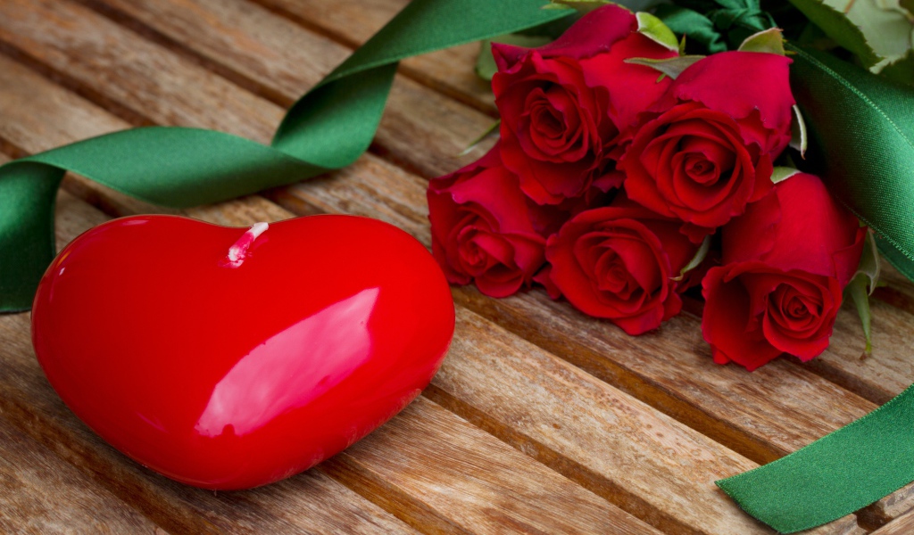 Большое сердце на деревянном столе с букетом красных роз 