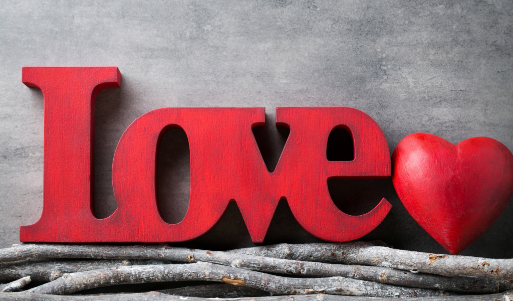 Большая надпись любовь на английском на фоне серой стены 