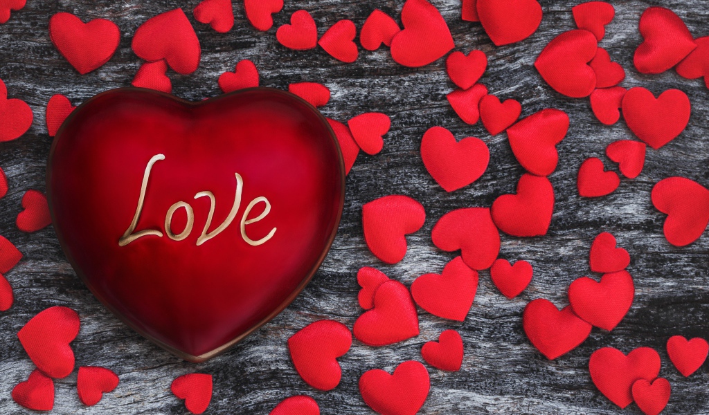 Большое красное сердце на деревянном фоне с маленькими сердечками