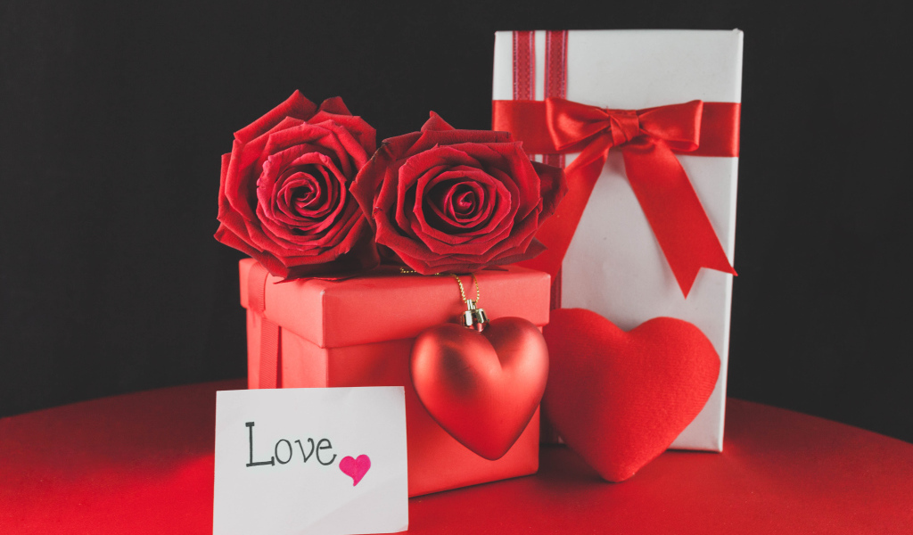 Коробки с подарками на столе с красными розами и сердцем