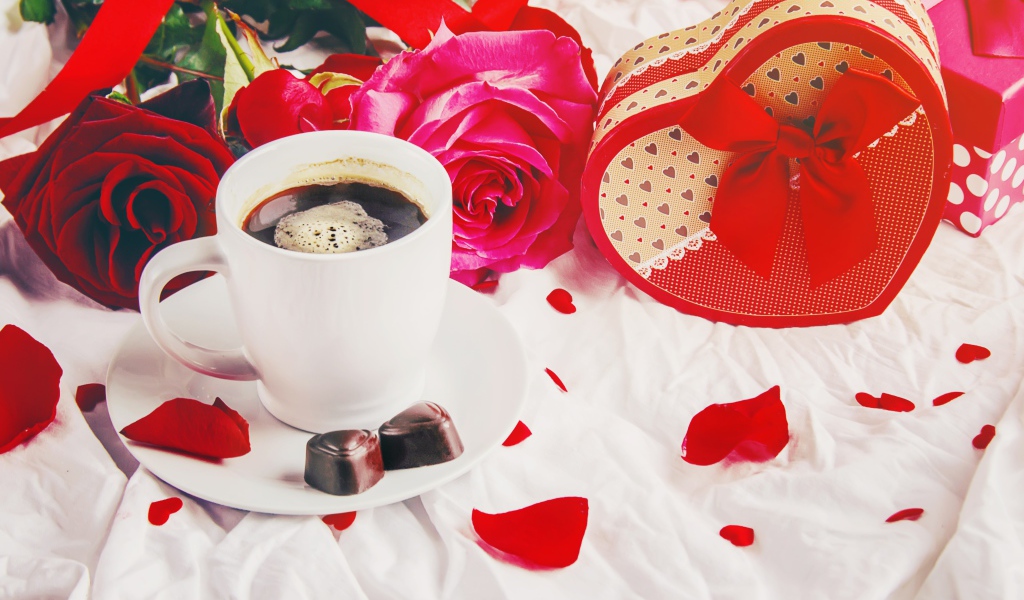 Коробка в форме сердца на белой ткани с чашкой кофе и розами