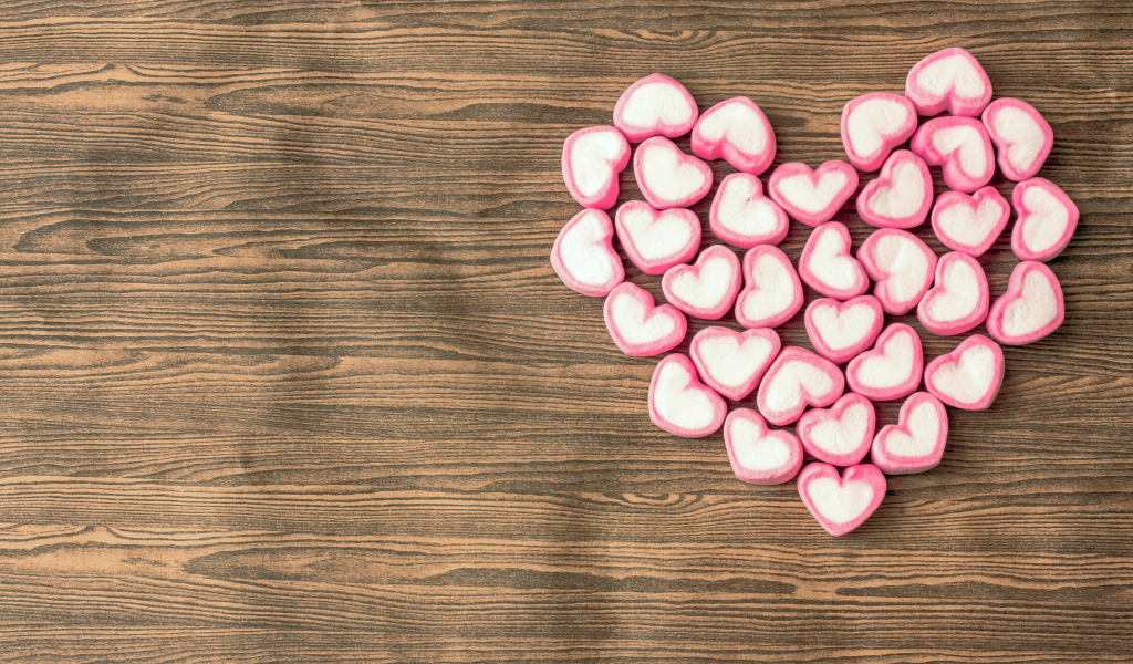 Сердце из конфет на деревянном столе