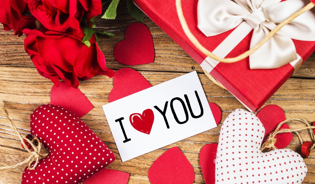 Сердечки, цветы и подарок на столе с запиской