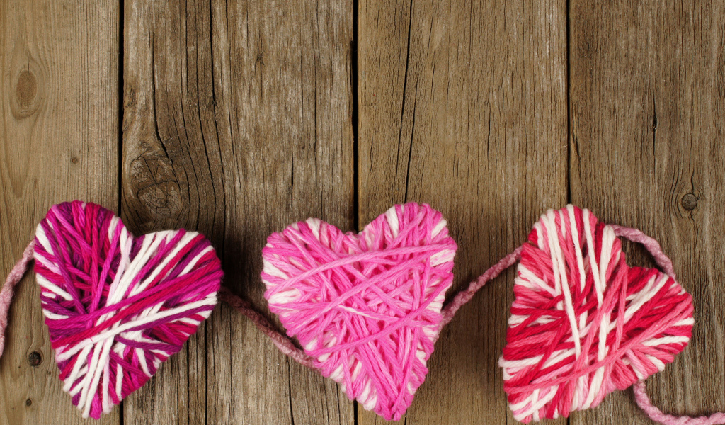 Сердца из ниток на деревянном столе