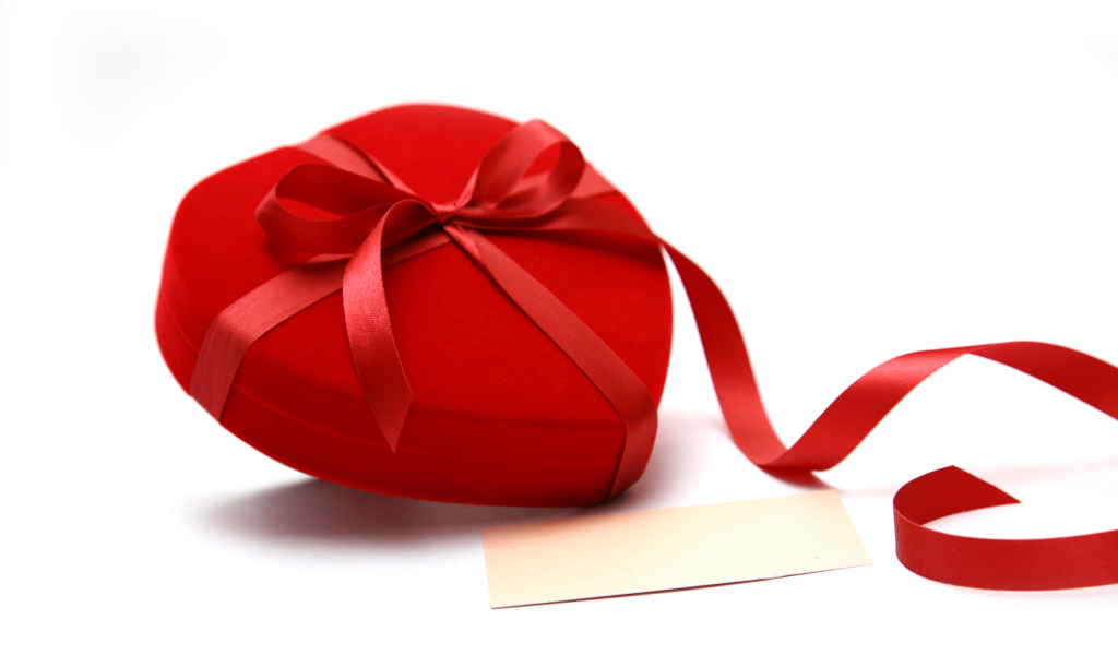 Красная коробка для ювелирных изделий в форме сердца на белом фоне 