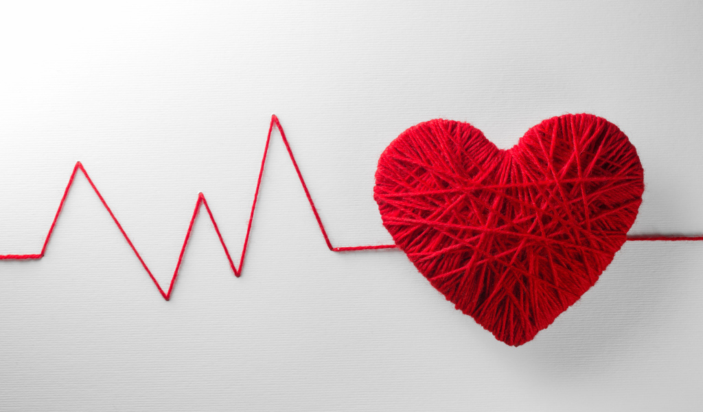 Красное сердце из нитей на сером фоне 