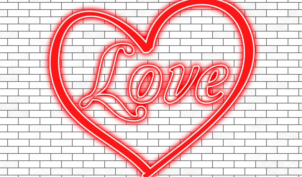 Красное сердце с надписью Любовь на кирпичной стене