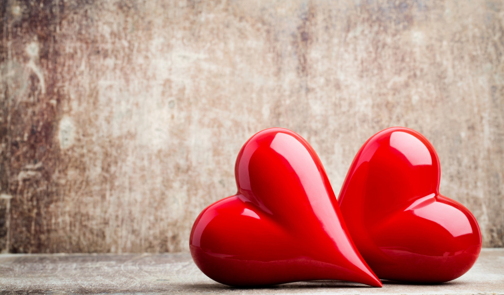 Два ярких красных сердца на сером фоне