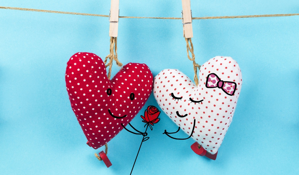 Два сердечка на прищепках на веревке на голубом фоне