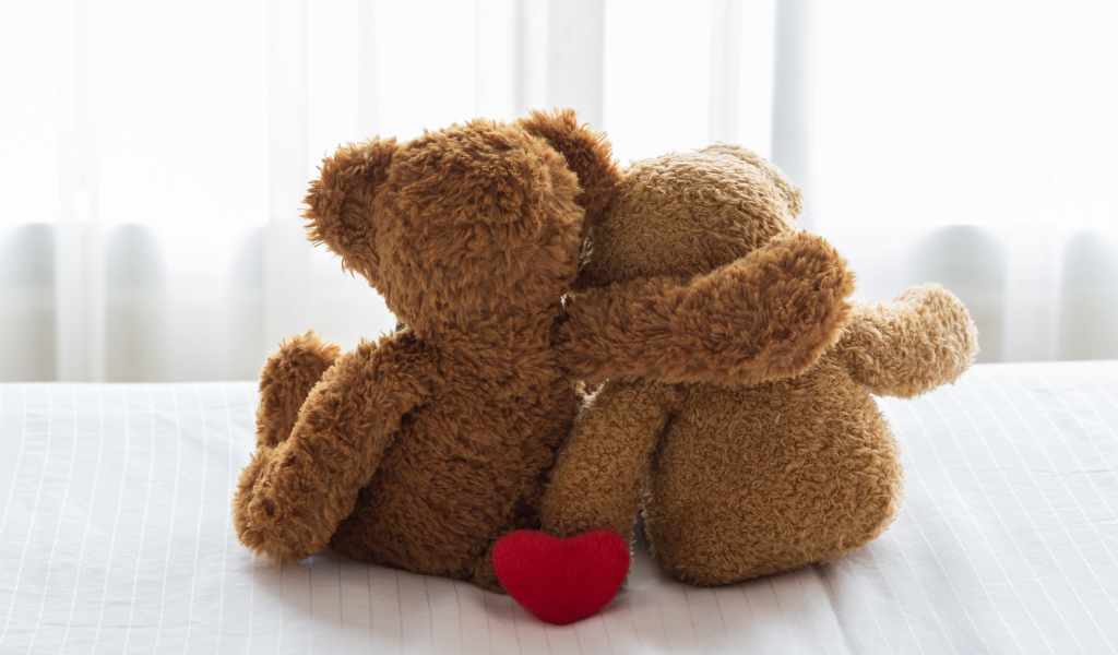 Два влюбленных плюшевых медвежонка на кровати