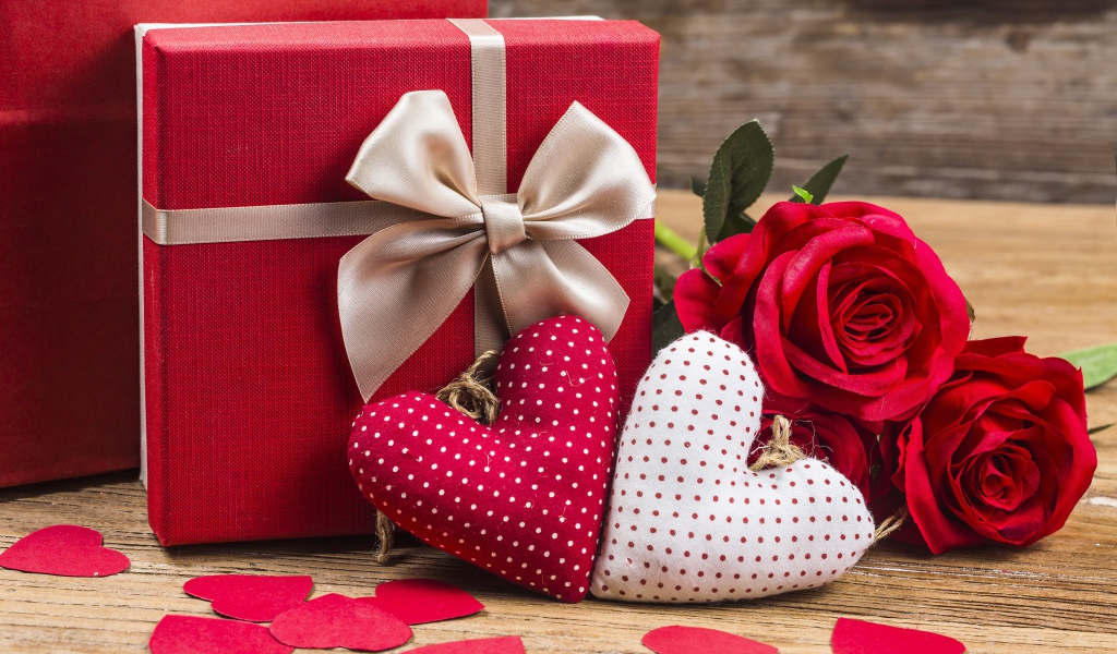 Два мягких сердечка на столе с подарком и розами для любимой