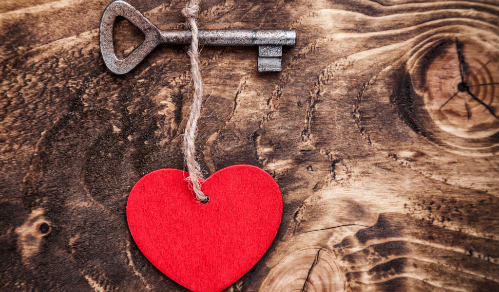 Деревянное сердце на столе с ключом 
