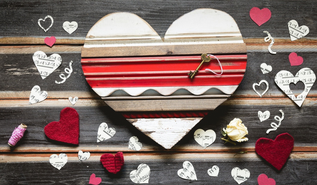 Деревянное сердце с бумажными сердечками на столе