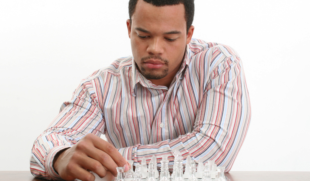 Мужчина в рубашке играет в стеклянные шахматы