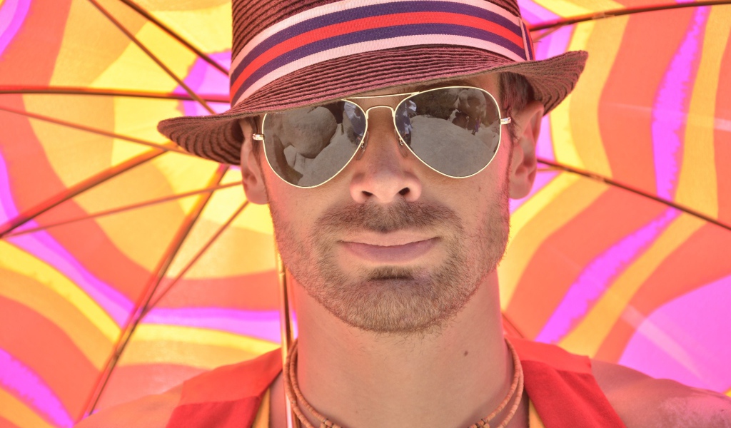 Мужчина в солнечных очках и шляпе летом