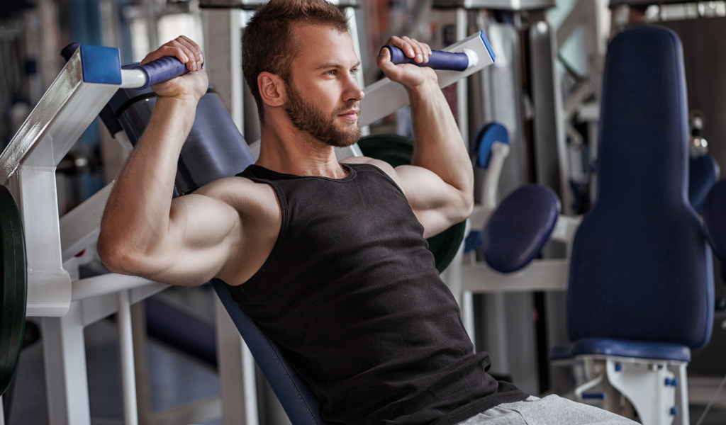 Накаченный мужчина занимается в спортзале