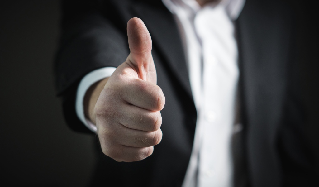 Мужчина в костюме показывает класс пальцем