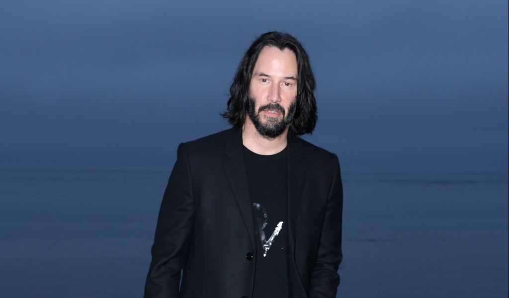 Актер Киану Ривз с бородой на синем фоне