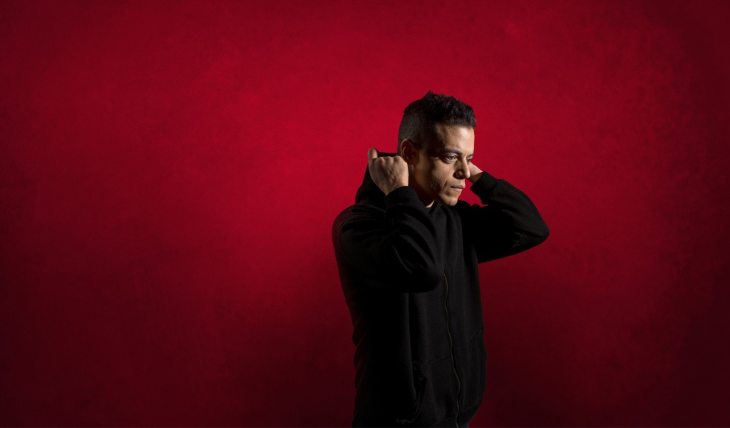 Актер Рами Малек на красном фоне