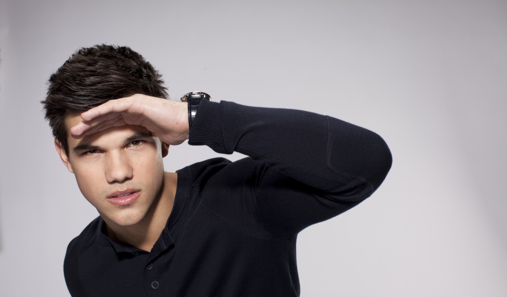 Красивый парень, актер Тейлор Лотнер на сером фоне