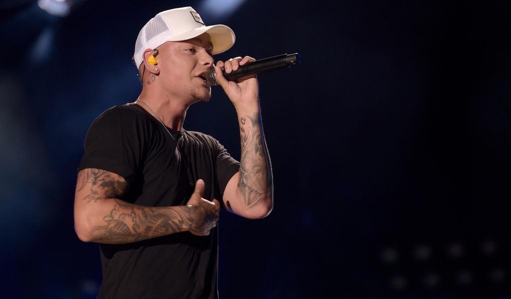 Американский кантри певец Кейн Браун с микрофоном на сцене