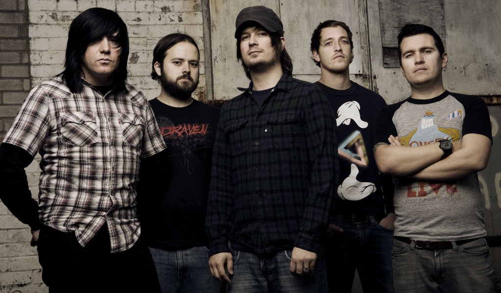 Музыкальная группа Funeral for a Friend стоят у старой стены