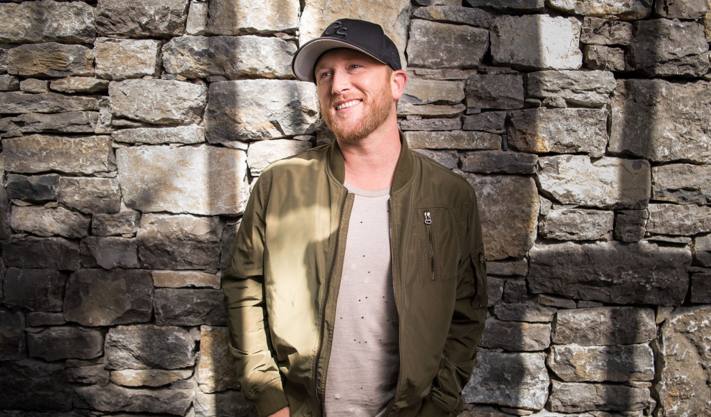 Музыкант Коул Суинделл в бейсболке у стены