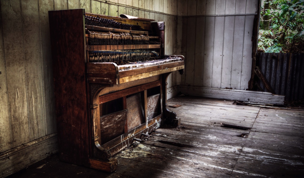 Old piano in the room of an abandoned house