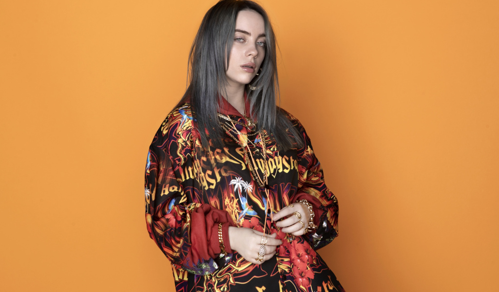 Певица Билли Айлиш на оранжевом фоне