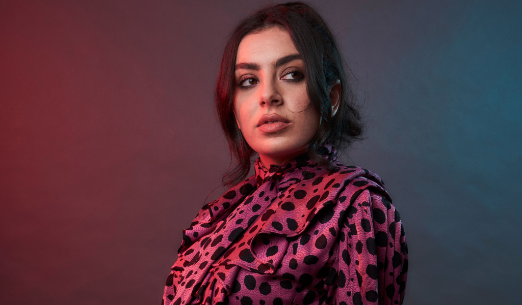 Певица Charli XCX на сером фоне
