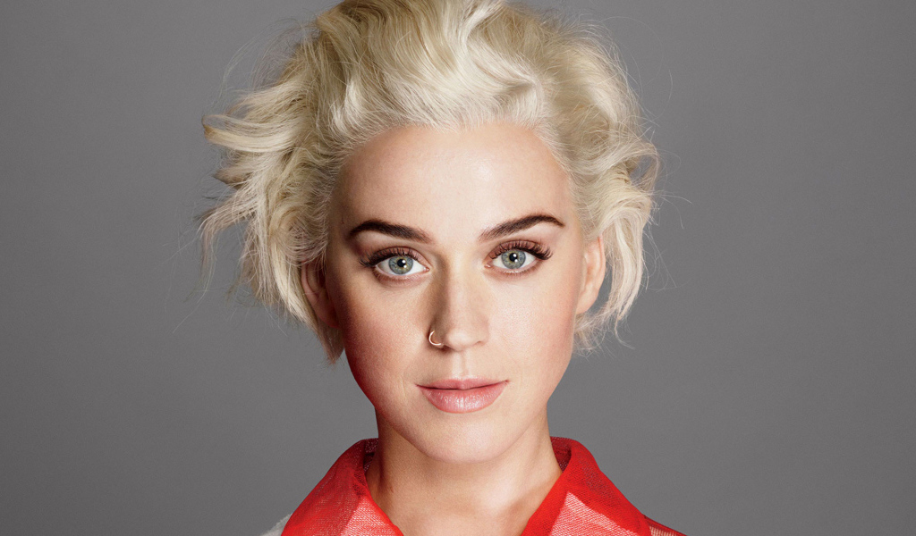 Певица Кэти Перри с короткой стрижкой на сером фоне