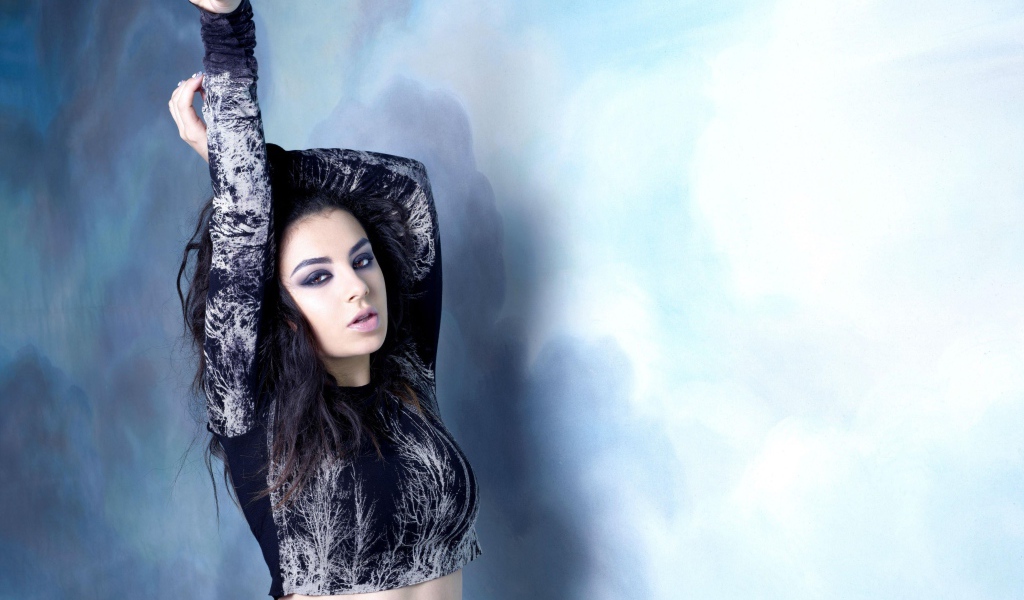 Молодая исполнительница Charli XCX  на голубом фоне