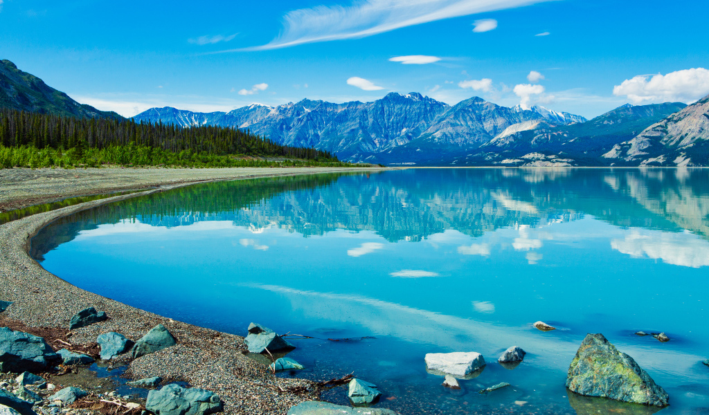 Красивое голубое озеро у заснеженных гор