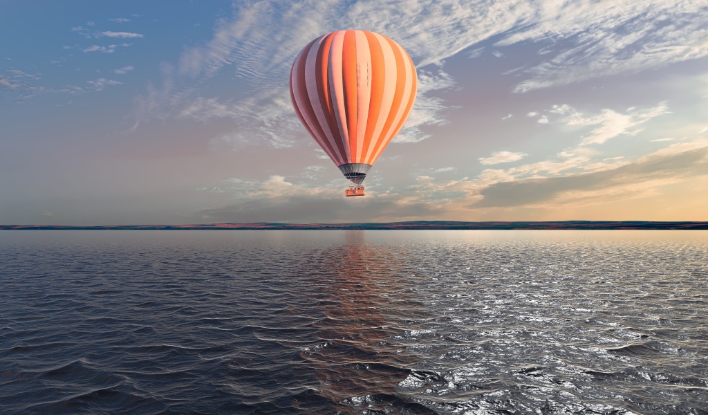 Большой оранжевый воздушный шар в небе над спокойной водой 