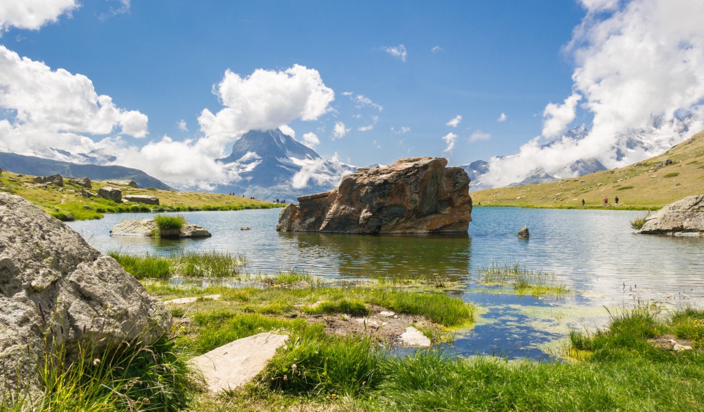 Большой камень в воде на фоне голубого неба