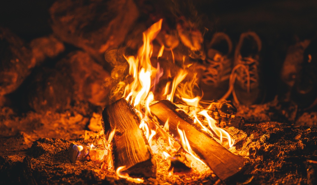 Дрова лежат в ярком огне костра