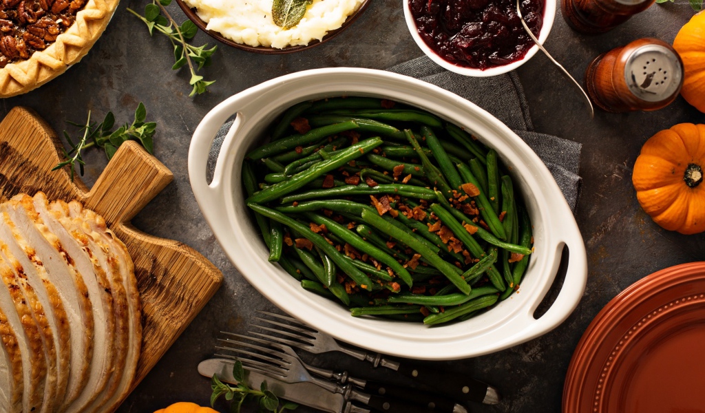 Зеленая фасоль в белой жаровне на столе 