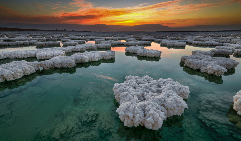 Соляные отложения в воде под красивым небом на закате