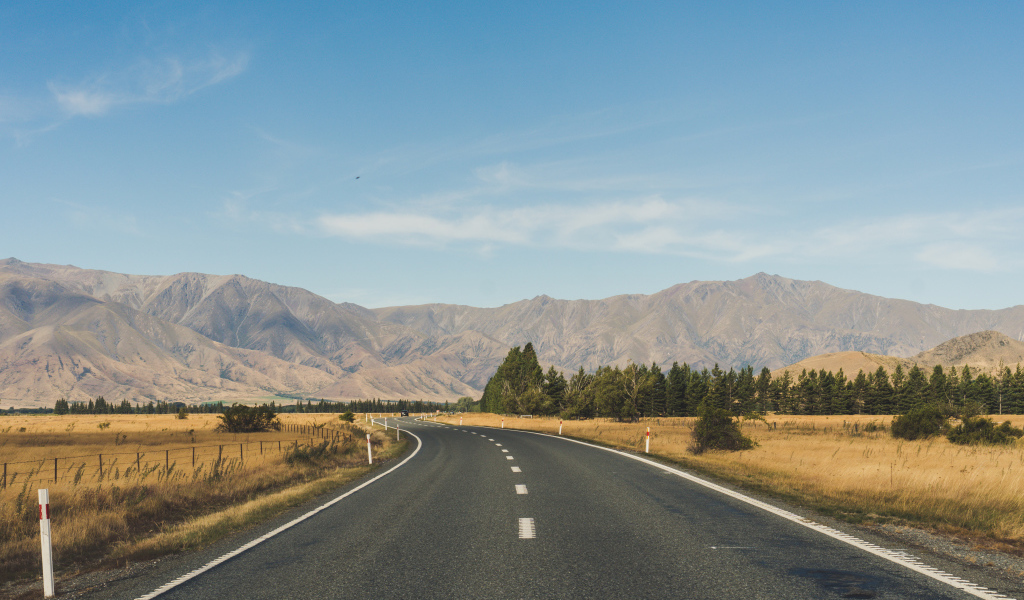 Ровная асфальтовая дорога на фоне гор 