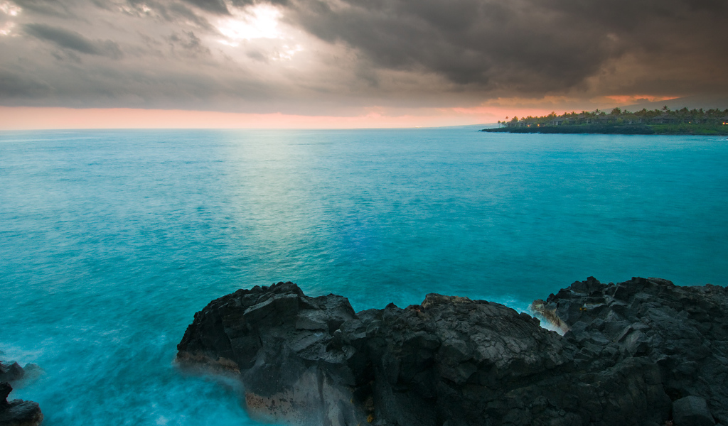 Камни в голубой воде океана под пасмурным небом