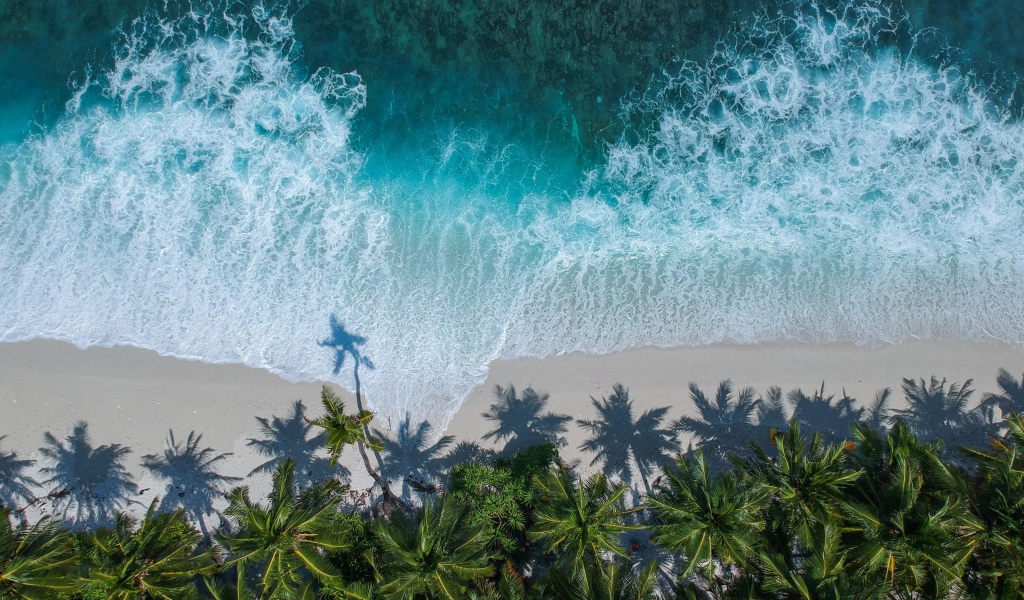 Белые волны океана на песке на тропическом пляже