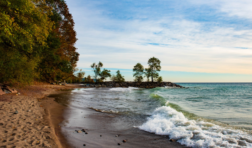 Белые волны океана на мокром песке под красивым небом