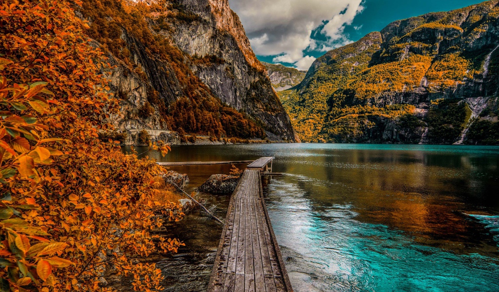 Wooden bridge in the water against the backdrop of the mountains