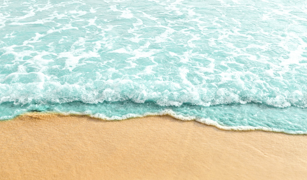 Голубая волна на теплом желтом песке летом