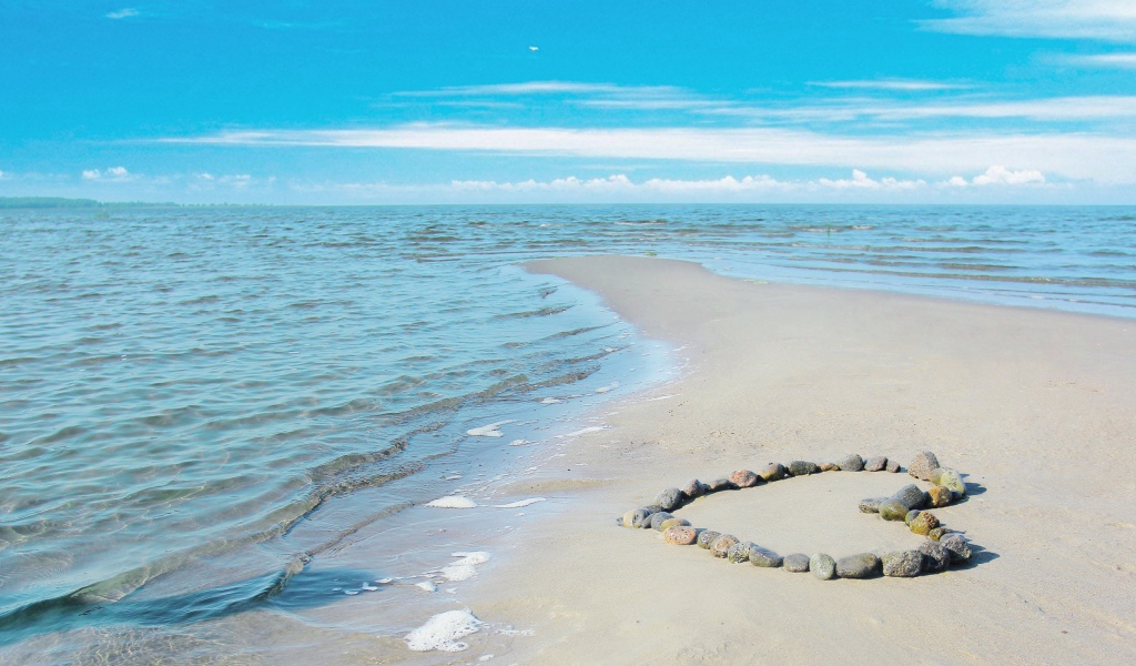 Сердце из камней на берегу теплого моря летом