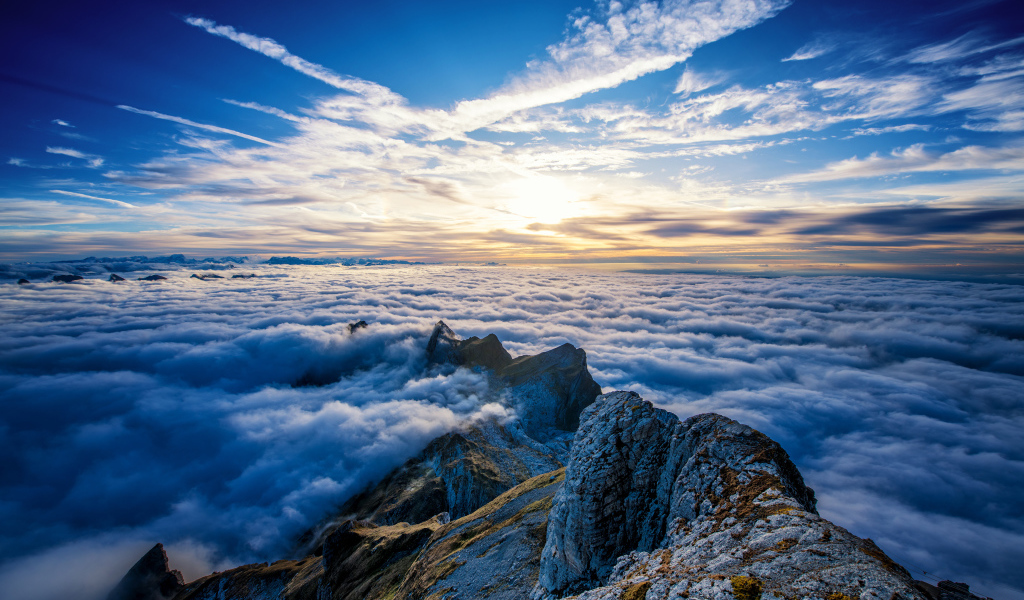 Густые белые облака над вершинами гор на рассвете