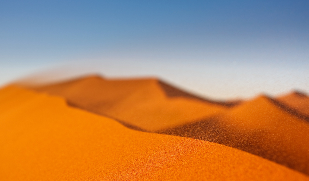 Желтый песок в пустыне под голубым небом