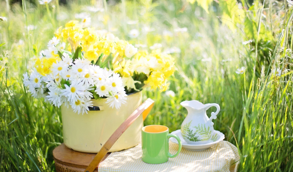 Букет цветов в кастрюле стоит на корзине 